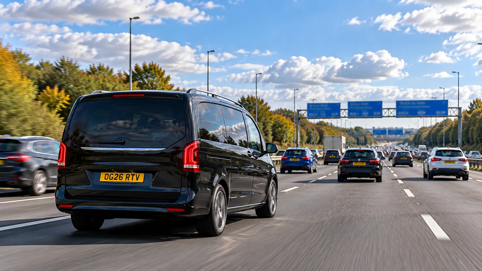 Black people carrier on the M25 near Heathrow on an Oxford Heathrow taxi, a plane landing overhead