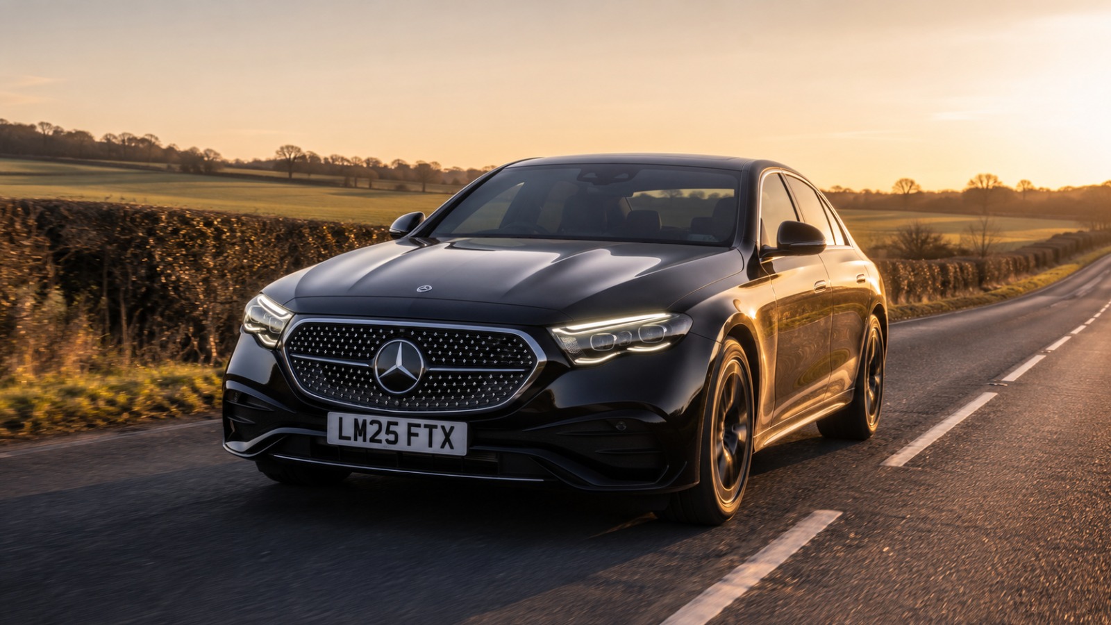 Fastlane Transfers black Mercedes E-Class 2025 Luton Airport taxi on a UK country road at golden hour.